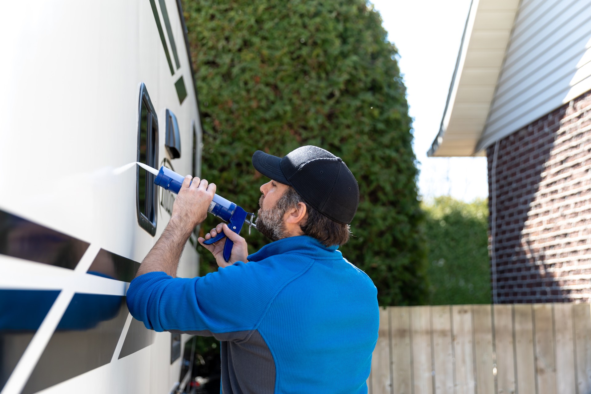 Man Doing Maintenance of Camper Trailer